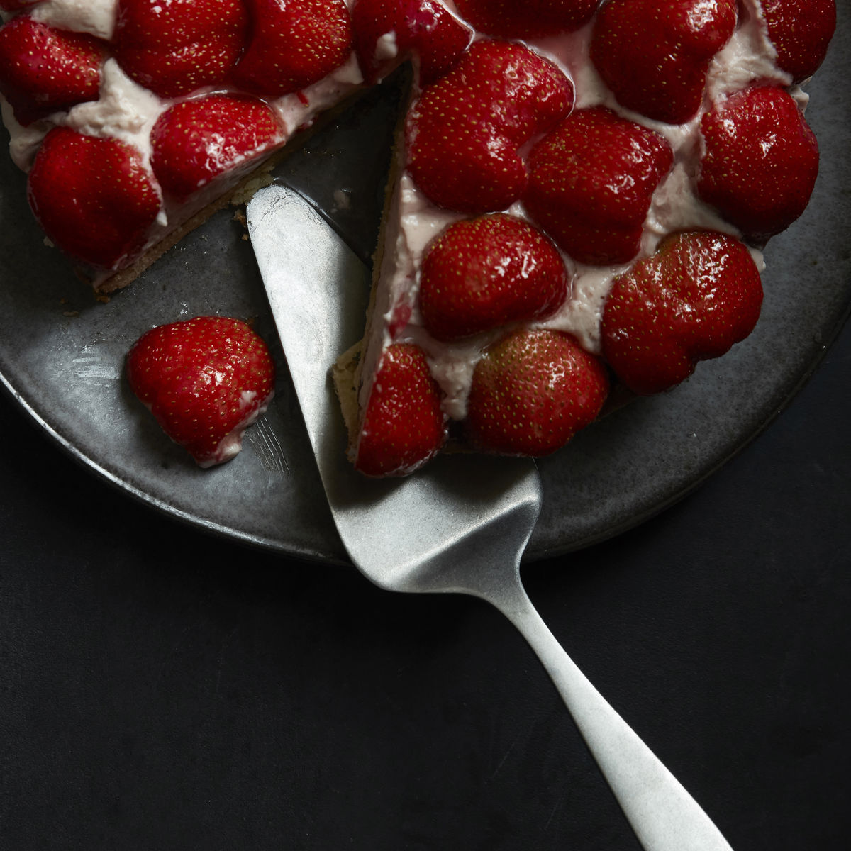 A stainless steel cake server with a hole in the top of the handle for hanging up after use.