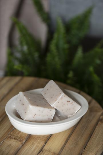 Two part ceramic soap dish. Oval shaped and cream coloured. The top part lifts out and has holes that let water drain. IB Laursen styling shot with soap.