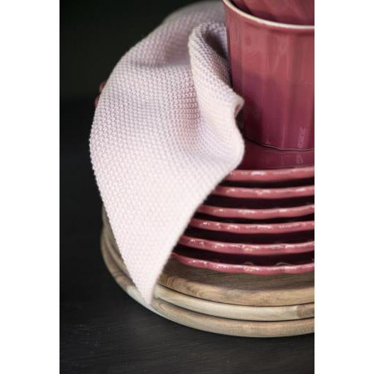 A square knitted cloth in a soft rose pink.