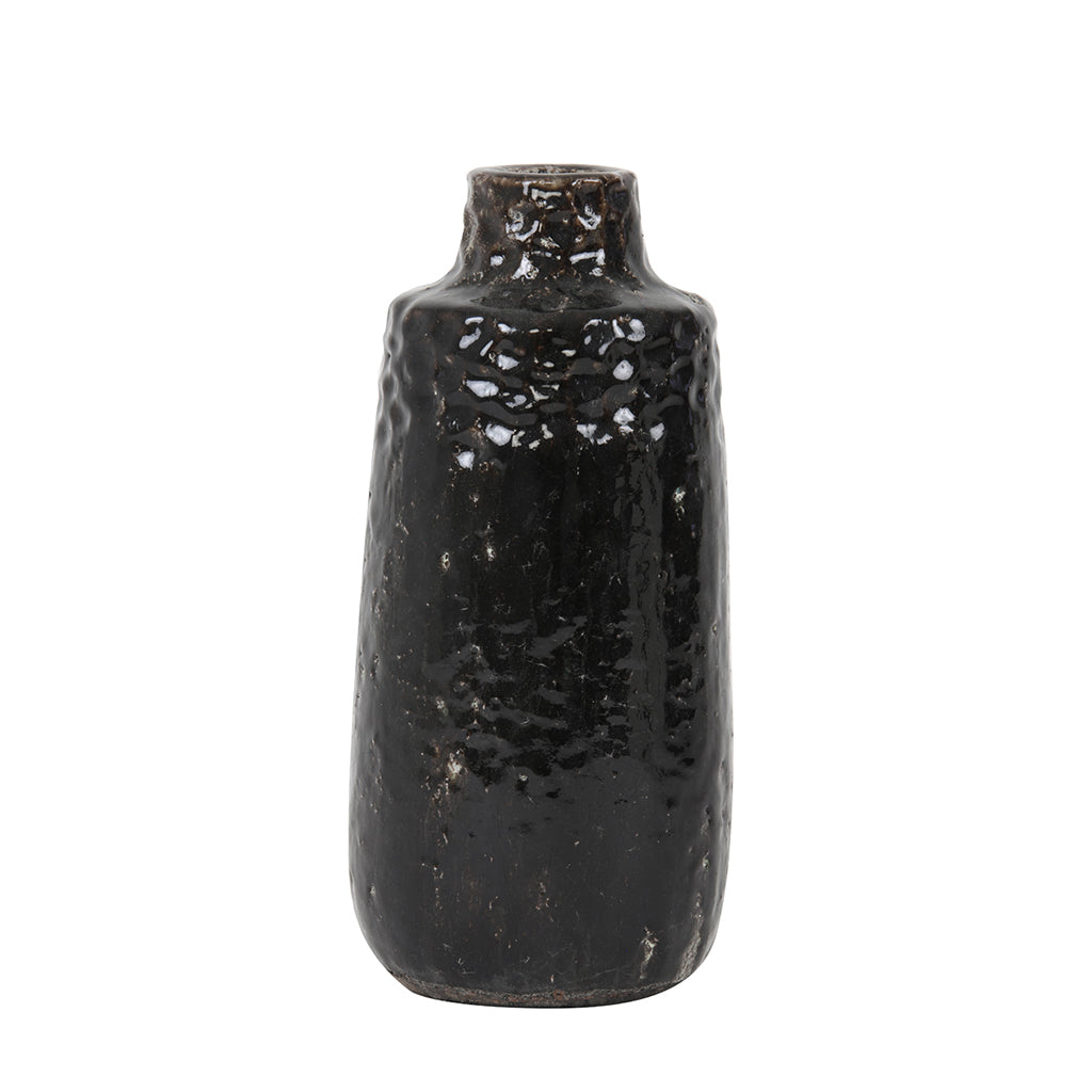 A dark chocolate brown ceramic vase, tall with an indent and narrower neck. Covered with indent marks as a part of the style.