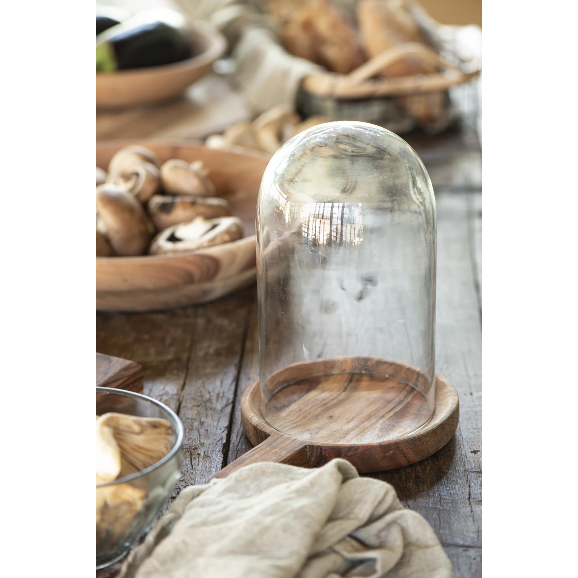 a round wooden dish made from a deep amber acacia wood, with a short handle.