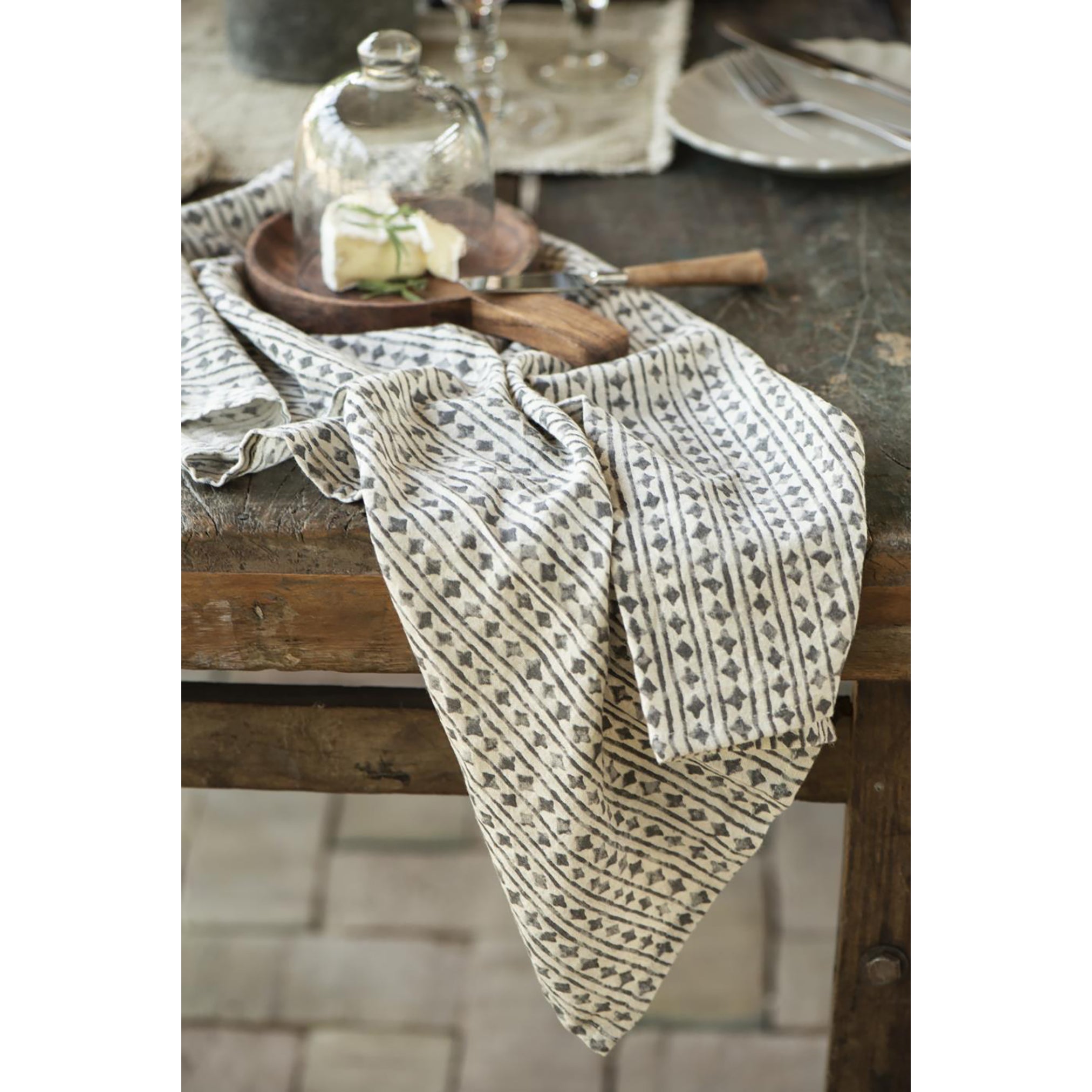 a round wooden dish made from a deep amber acacia wood, with a short handle.