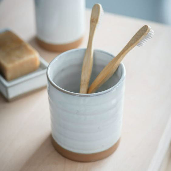 Small ceramic pot part glazed in off-white, with the base in a sandy coloured ceramic. 