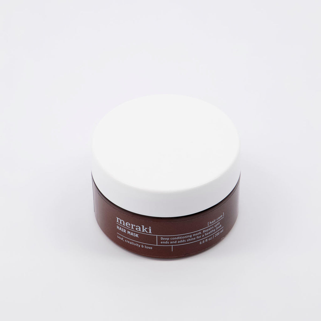 A deep conditioning hair mask in a round tub, brown with a white lid.