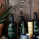A dark green bottle with black pump and a label that says 'Meraki Face & Body Lotion'